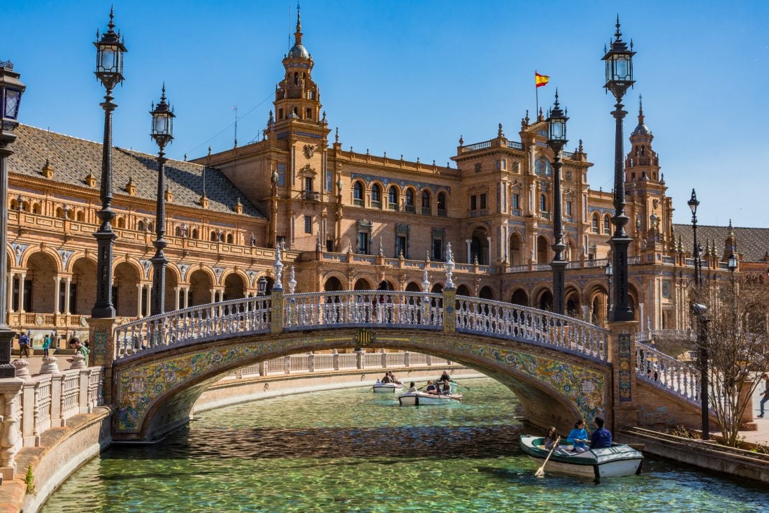 A view of rowboats under a bridge in the small moat in Plaza de Espana, Sevilla