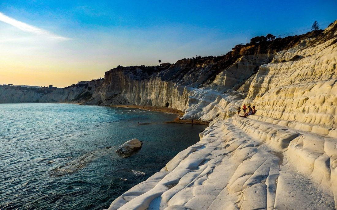 people sitting on rocks on the shore of Scala dei Turchi, Sicily