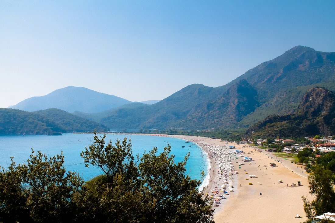 People sitting by the shore of Olüdeniz Beach