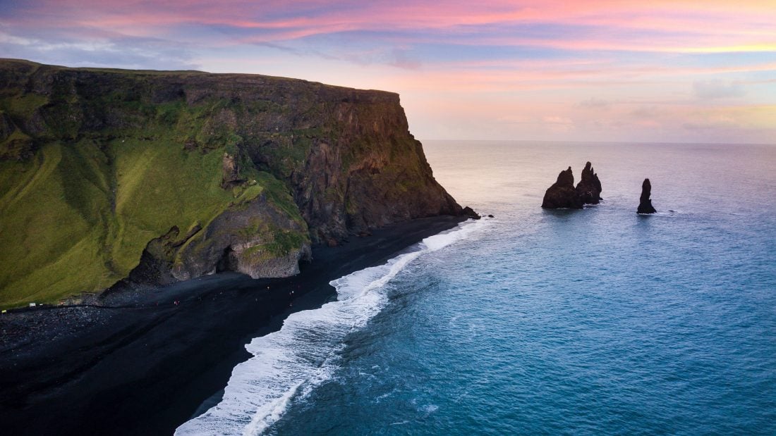 Sunset over the black sands and cliff of Reynisfjaba Beach