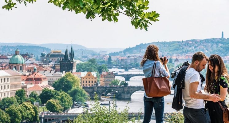 three people looking out over the river and bridges of Prague from Letna Park