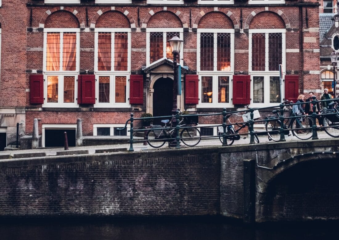 bicycles locke dup to a railing near the canal in amsterdam