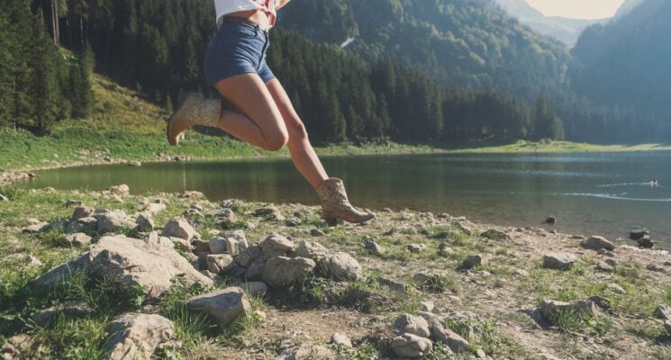 woman in boots jumping by a lake in nashville