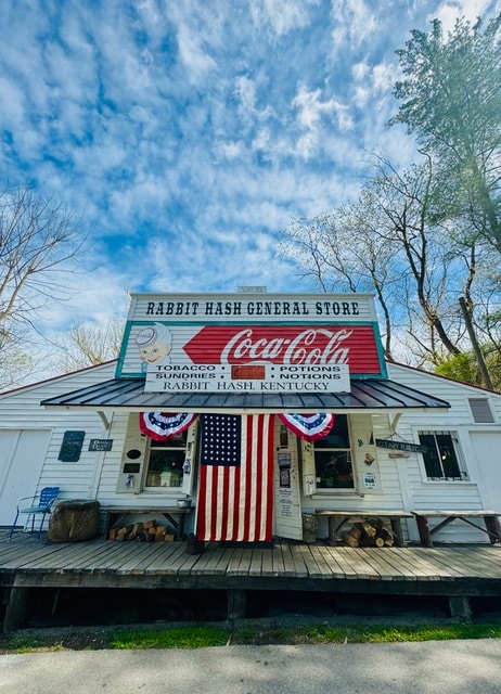 Rabbit Hash General Store storefront with a large American flag on a sunny day.