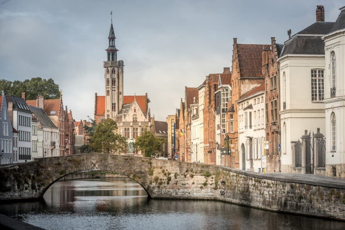 A bridge stretching over a canal lined with buildings in Bruges.